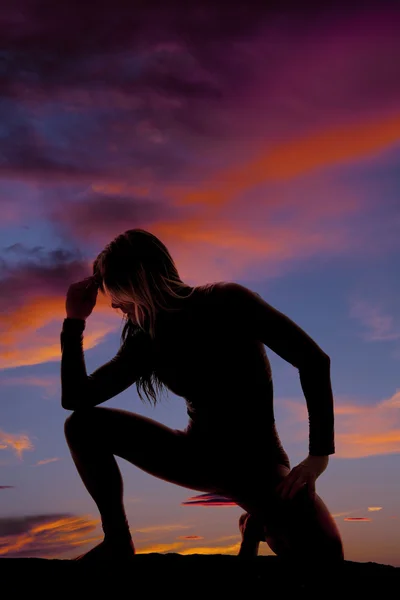 Silhueta de uma mulher para baixo cotovelo no joelho no pôr do sol — Fotografia de Stock