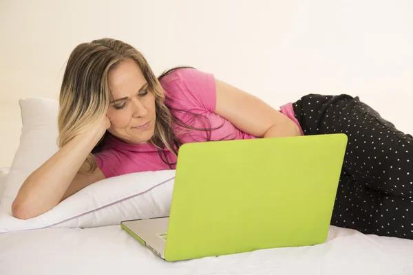 Woman in pajamas with laptop lay funny face — Stock Photo, Image