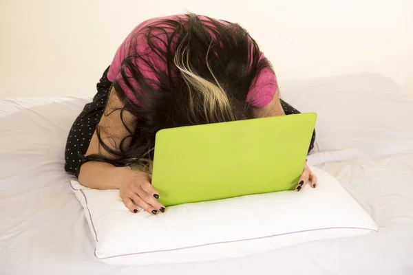 Mujer en la cabeza de almohada hacia abajo en el ordenador portátil — Foto de Stock