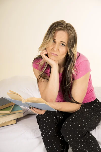 Nő az ágyban olvas könyv szomorú Stock Kép