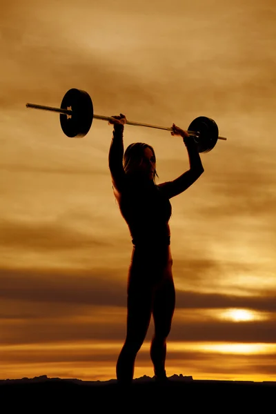 Silhouette of fit woman barbell over head — Stock Photo, Image