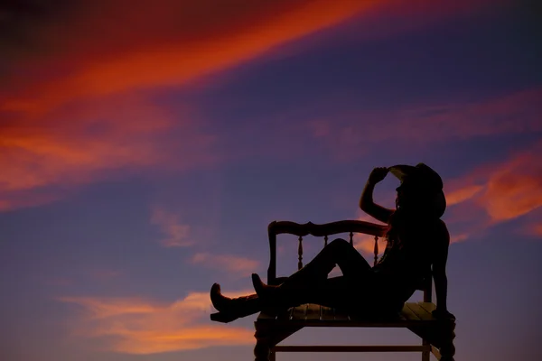 Western girl on bench silhouette — Stock Photo, Image