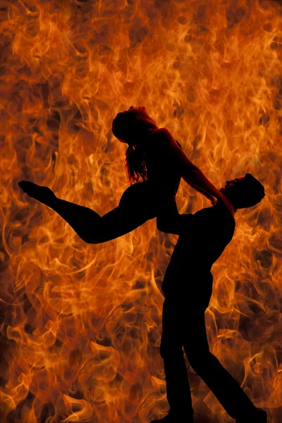 Silhueta casal dança ele levanta-la até fogo — Fotografia de Stock