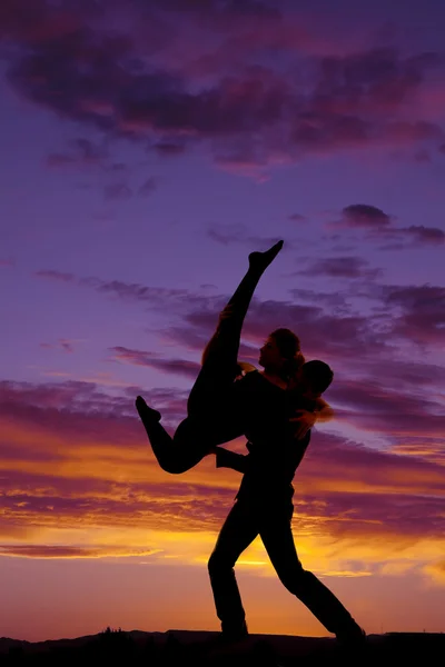 Silhouette couple dancing lifting her up leg up — Stock Photo, Image