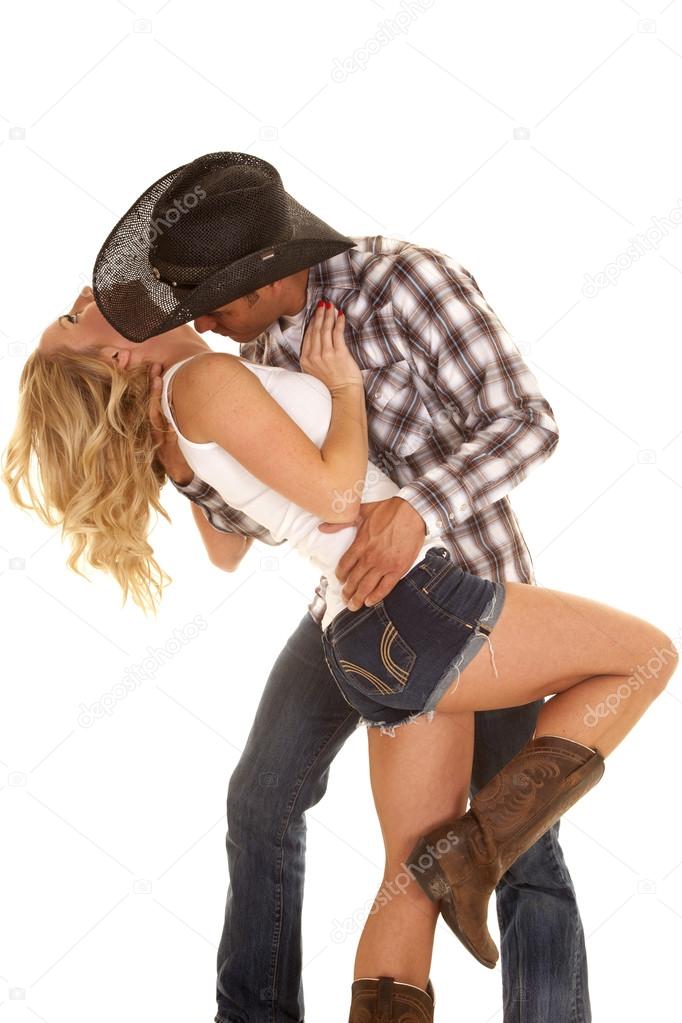 Cowboy getting ready to kiss woman's neck.