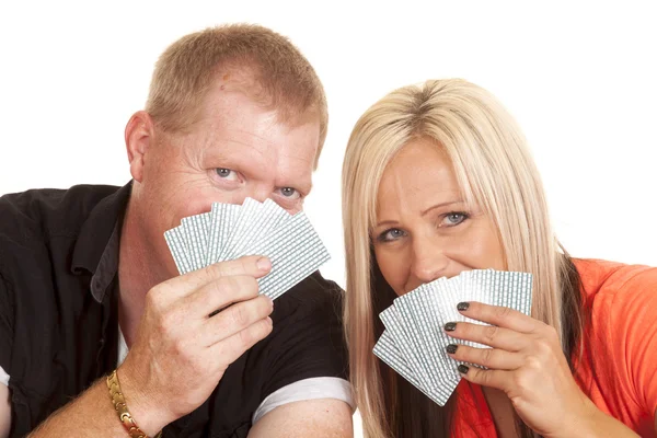 Homem e mulher sorriem atrás de cartas de jogo — Fotografia de Stock