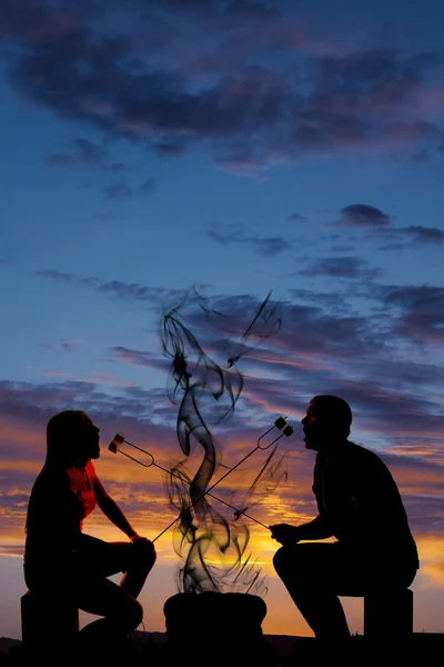 Silhouette man and woman eating each others marshmallows — Stock Photo, Image