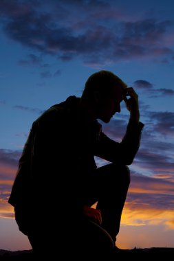 adam silüeti diz kafasına günbatımı elinde