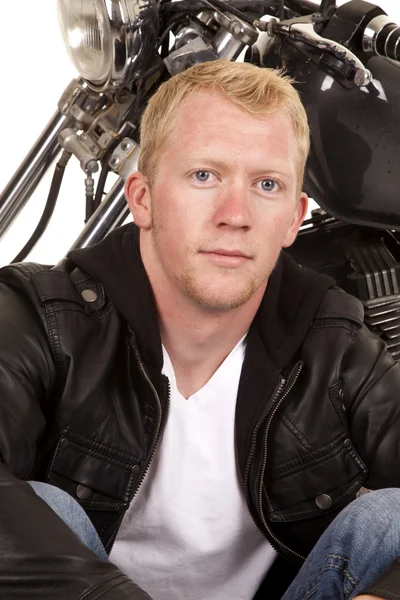 Man in black jacket motorcycle behind him — Stock Photo, Image