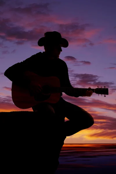 Silhueta de homem com guitarra sentar-se ao pôr-do-sol água — Fotografia de Stock