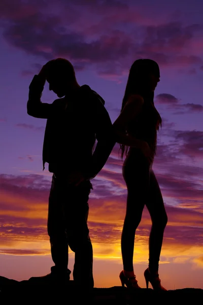 Silhouet van het paar rug aan rug in de zonsondergang — Stockfoto