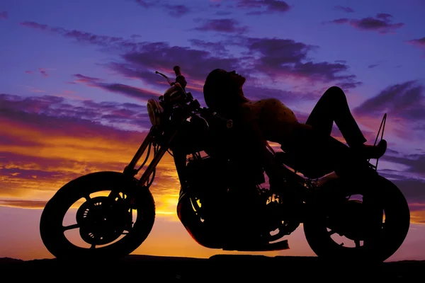 Vrouw silhouet op motorfiets lag op tank — Stockfoto