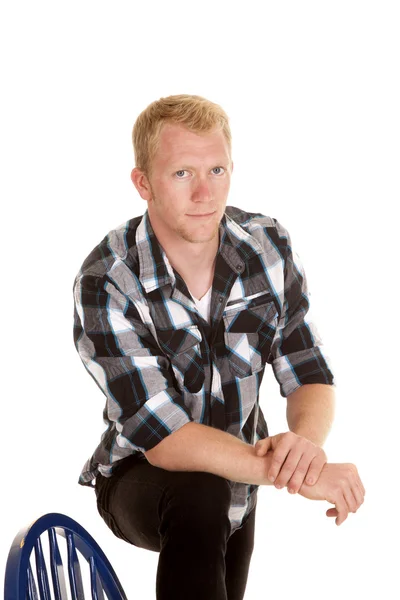 Homme en chemise à carreaux pied sur chaise grave — Photo