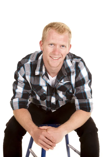 Człowiek w plaid shirt siedzieć chudego uśmiech do przodu — Zdjęcie stockowe