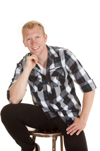 Man in plaid shirt zitten kijken glimlachen — Stockfoto