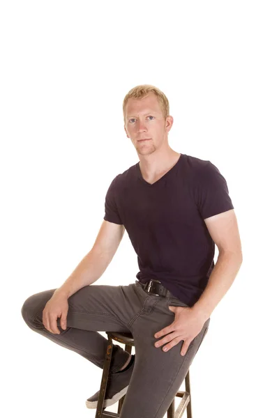 Человек в фиолетовой рубашке сидит на табуретке — стоковое фото