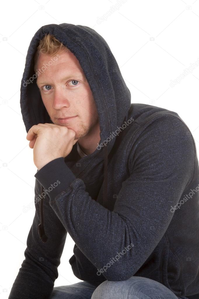 man in hoodie looking close hand chin smile
