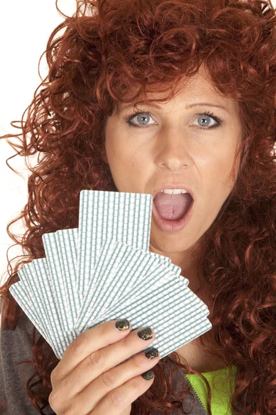 Vrouw rood haar blik over fan van kaarten schok — Stockfoto