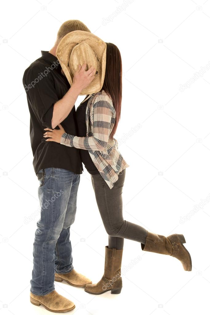 couple kiss behind hat leg up