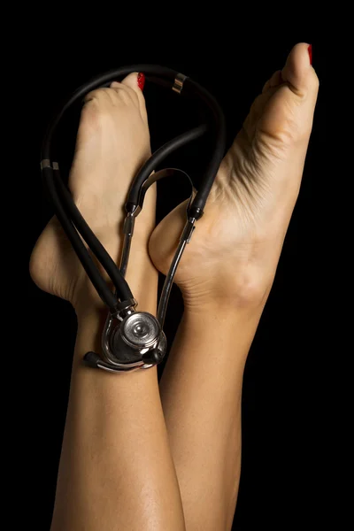 Frauenbeine und Stethoskop — Stockfoto