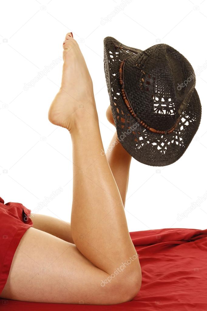 Woman's legs up with a western hat