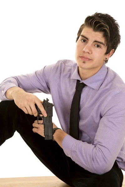 Hombre en vestido púrpura camisa y pistola sentarse buscando —  Fotos de Stock