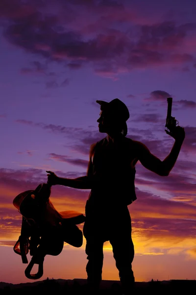 Cowboy segurando uma sela e arma — Fotografia de Stock