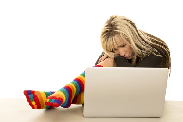 Mujer en calcetines de colores con ordenador — Foto de Stock