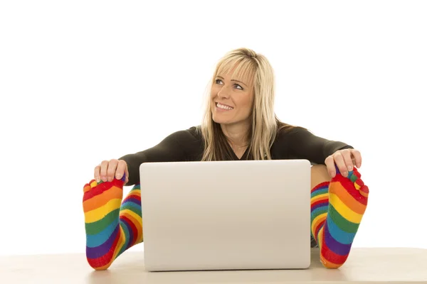 Женщина в цветных носках с компьютером — стоковое фото