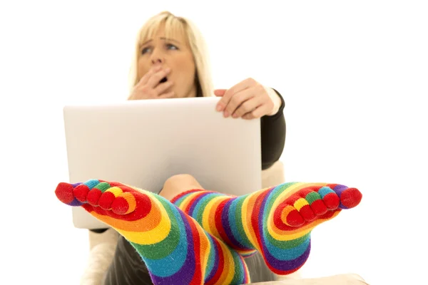 Frau trägt helle Socken mit Laptop — Stockfoto