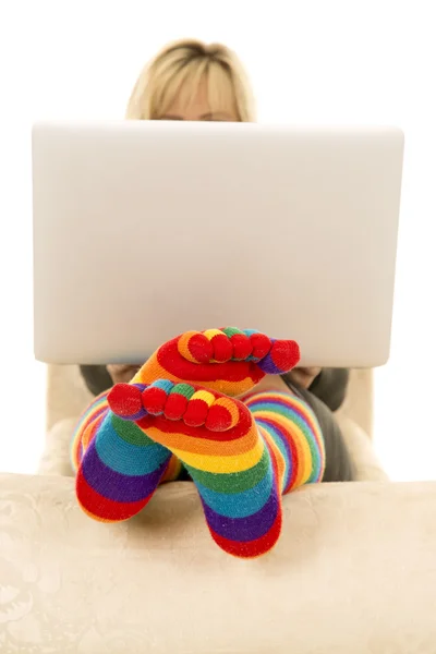 Vrouw heldere sokken met laptop te dragen — Stockfoto