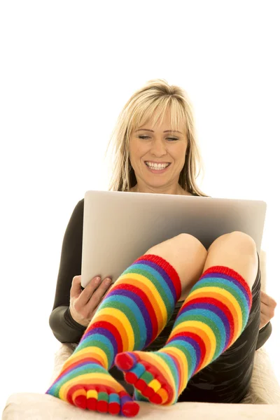 Женщина в ярких носках с ноутбуком — стоковое фото