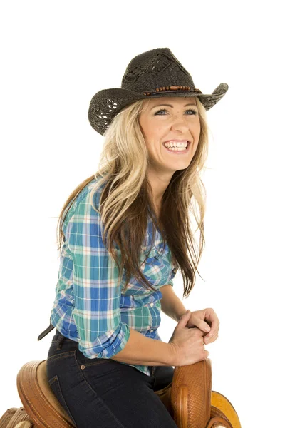 Cowgirl sitting on a saddle — Stock Photo, Image