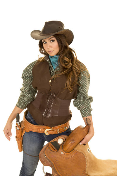 Young cowgirl with saddle