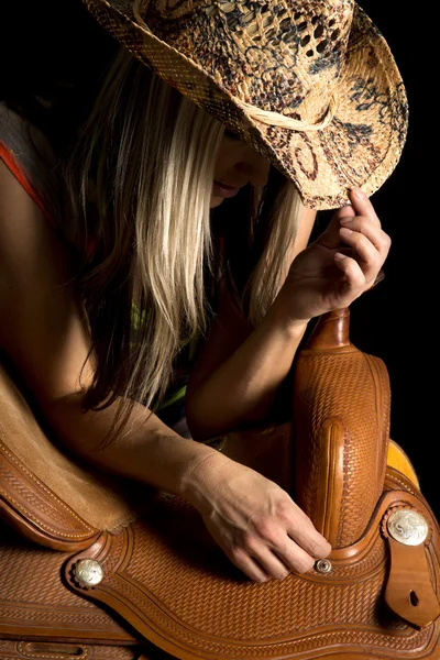 Cowgirl leaning on saddle — Stock Photo, Image