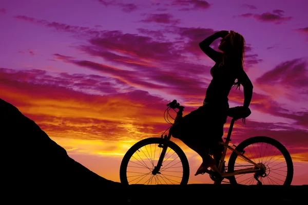 Silhueta de uma mulher em uma bicicleta — Fotografia de Stock