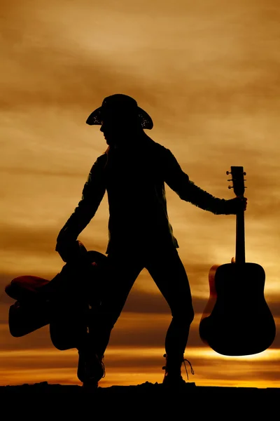 Silhouette of woman with saddle and guitar — Stock Photo, Image