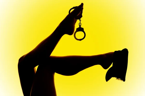 Силуэт женских ног с наручниками — стоковое фото