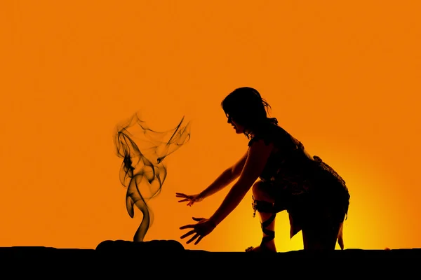 Silhouette einer Höhlenfrau durch Feuer — Stockfoto