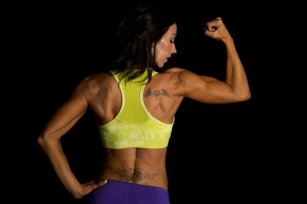 Woman flexing on black — Stock Photo, Image