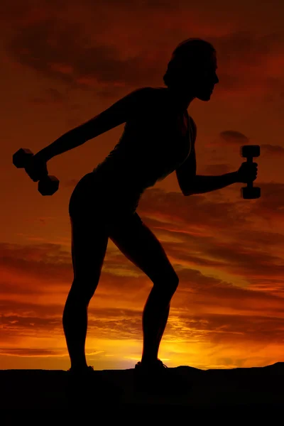 Silhouette della donna che si esercita con i manubri — Foto Stock