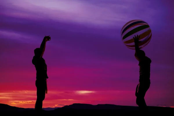 Silhouette de garçons jetant ballon de plage — Photo