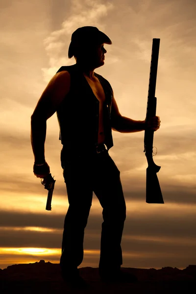 Силуэт ковбоя с дробовиком и пистолетом — стоковое фото