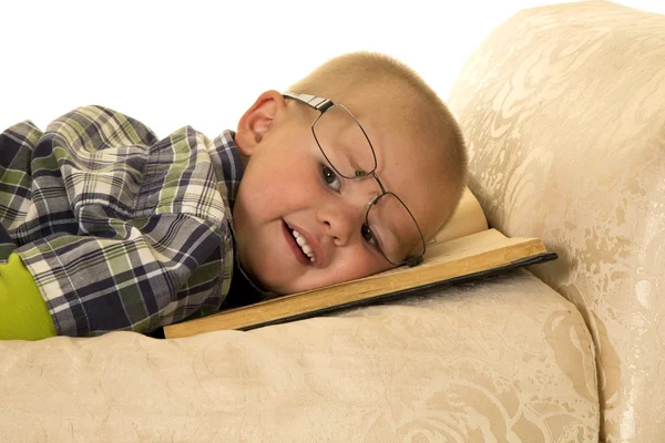 Kleiner Junge liegt mit Buch — Stockfoto