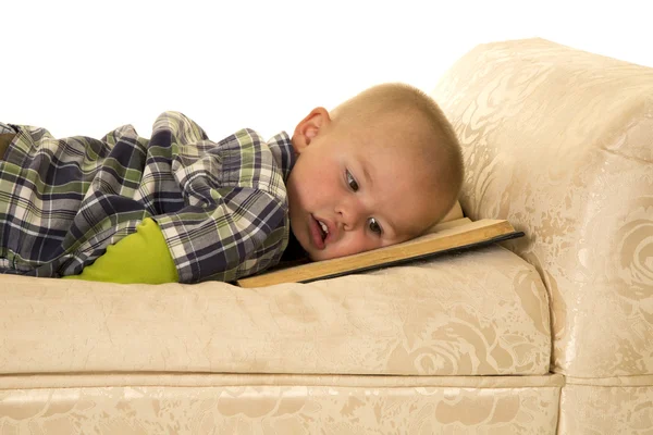 Мальчик, лежащий на книжке — стоковое фото