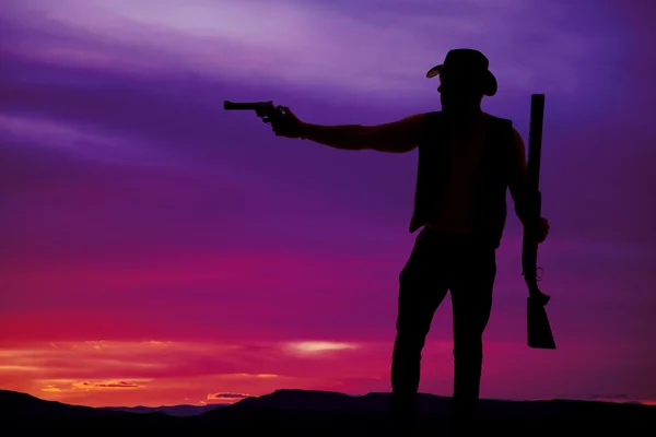 Silhouette eines Cowboys, der mit Gewehr schießt — Stockfoto