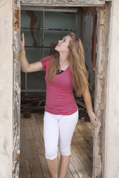 Meisje in de deuropening van oude huis — Stockfoto