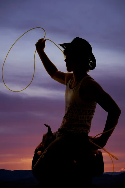 Silhueta de um cowboy em uma sela com uma corda — Fotografia de Stock