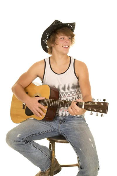 Mladý muž hraje na kytaru s kovbojský klobouk úsměv — Stock fotografie