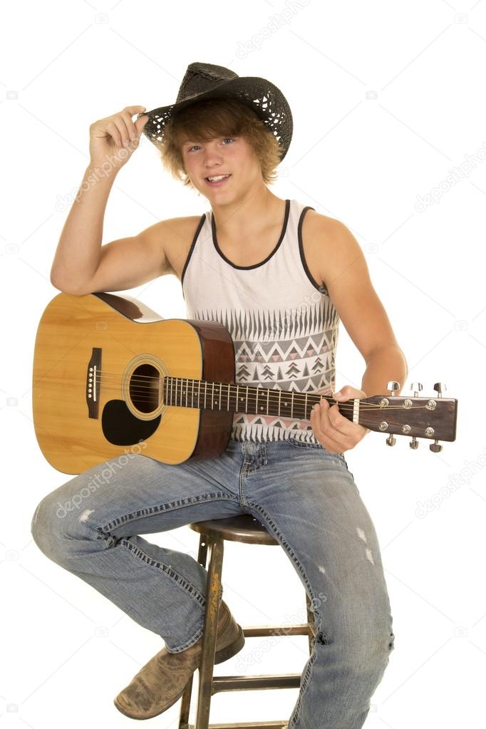 young man playing a guitar with cowboy hat looking